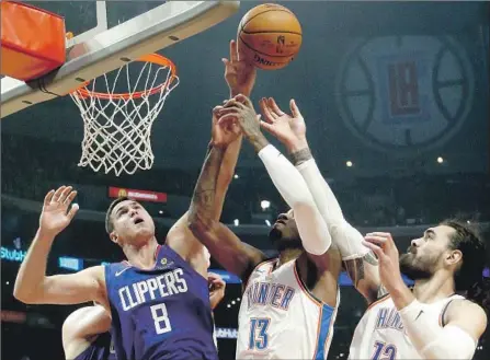  ?? Ringo H.W. Chiu Associated Press ?? DANILO GALLINARI, who scored 10 of his 26 points in the third quarter to keep the Clippers close, battles Oklahoma City’s Paul George (13) and Steven Adams for a rebound. Gallinari and frontcourt mate Tobias Harris shared the game high for points scored.