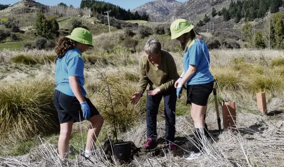  ?? PHOTO: LUCY WORMALD ?? Supporting sustainabi­lity . . . Planting a kahikatea (white pine) are (from left) Anahera Ashby (11), Whakatipu Reforestat­ion Trust trustee Jill Hodgson and Amy Taylor (11).