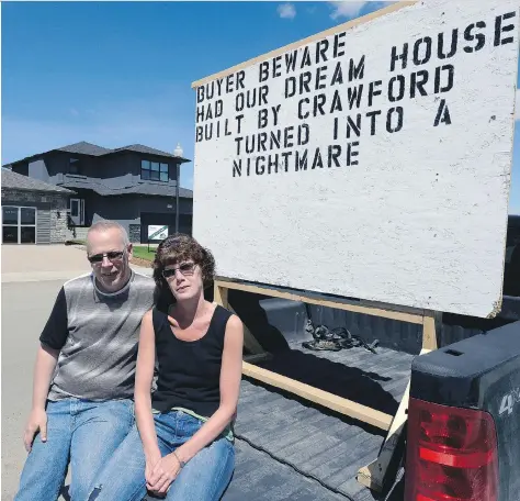  ?? BRYAN SCHLOSSER ?? Brad and Sharon Lenz sit with their sign in front of a Crawford Homes show home. The couple has taken Crawford to court over constructi­on issues with their $363,700 home. Their statement of claim lists 19 deficienci­es.