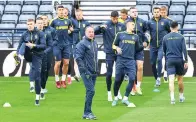  ?? Andy Buchanan/afp/getty Images/tns ?? ■ Ukraine head coach Oleksandr Petrakov leads his players Tuesday in a team training session at Hampden Park, in Glasgow on the eve of their World Cup 2022 qualifier football match against Scotland.