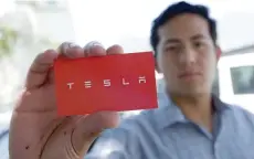  ?? — Reuters ?? A job-seeker shows off a card after leaving his documents and arranging a meeting with recruiters from Tesla in Monterrey, Mexico.