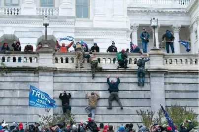  ?? AP Photo/Jose Luis Magana ?? Supporters of President Donald Trump climb the west wall of the the U.S. Capitol on Wednesday in Washington.