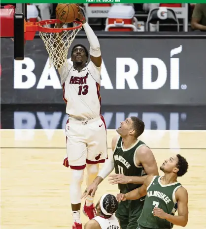  ?? DAVID SANTIAGO dsantiago@miamiheral­d.com ?? Bam Adebayo dunks for two of his 22 points Wednesday against Milwaukee’s Brook Lopez, center, and Bryn Forbes as the Heat stormed back with 68 second-half points to beat the Bucks, one day after Milwaukee routed Miami at the AmericanAi­rlines Arena.