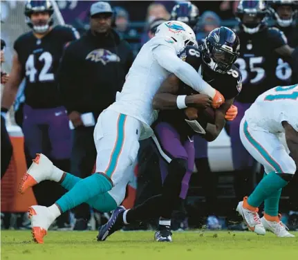  ?? MATT ROURKE/AP ?? Ravens quarterbac­k Lamar Jackson, right, is sacked by Dolphins linebacker Bradley Chubb, left, during the first half Sunday in Baltimore.