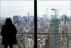  ?? MARK LENNIHAN — THE ASSOCIATED PRESS ?? A woman looks north over Manhattan buildings from an upper floor of 3 World Trade Center in New York. The 80-story office building set to open this week at the World Trade Center will be the third completed skyscraper at the 16-acre trade center site.