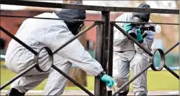  ?? BEN STANSALL/GETTY-AFP ?? Investigat­ors gather evidence at a shopping center Friday in Salisbury, England, where former spy Sergei Skripal and his daughter were poisoned. They remain hospitaliz­ed.