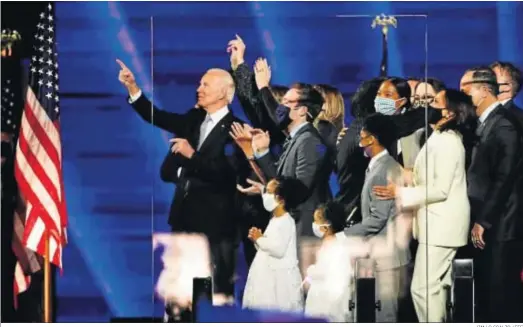  ?? JIM LO SCALZO / EFE ?? Joe Biden saluda desde el escenario en Wilmington (Delaware), donde celebró su victoria, arropado por su familia y la de Kamala Harris.