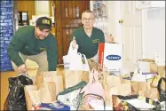 ?? Lara Green-Kazlauskas / For Hearst Connecticu­t Media ?? Torrington Area Railroader­s members John Dunbar and Jac LaBeck help pack food donations during Sunday’s train show and food drive at the Torrington Armory.