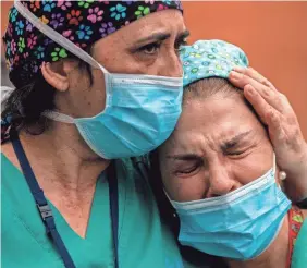  ?? MANU FERNANDEZ/AP ?? Health workers cry during a memorial for their co-worker who died from COVID-19 in April.