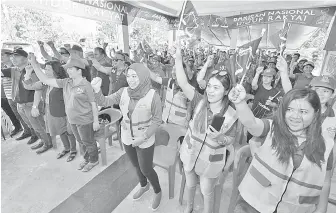  ??  ?? SEBAHAGIAN penduduk kampung melaungkan slogan ‘BN Onsoi’ di PDM Ulu Bole.