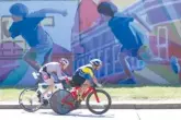  ??  ?? Adam Weeks, No. 2143, from Hickory, N.C., and TinTin Rexach, No. 437, from Puerto Rico ride past a mural.