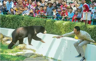  ?? AKHMAD RIZAL/JAWA POS ?? SARAT EDUKASI: Pengunjung memadati kandang beruang madu sumatera saat acara keeper talk di KBS kemarin.