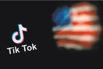  ?? Nicolar Asfouri / AFP via Getty Images ?? This photo illustrati­on shows the logo of TikTok and a U.S. flag on the screens of two laptops in Beijing. The company has agreed to a deal with Oracle, but the details are private.