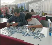  ?? JULIE JACOBS ?? A.J. Jacobs shows Jacobs and his son Zane, 13, during an event at the 2019 World Jigsaw Puzzle Championsh­ip in Spain. There were 40countrie­s represente­d at this competitio­n.