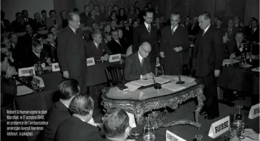  ??  ?? Robert Schuman signe le plan Marshall, le 17 octobre 1948, en présence de l’ambassadeu­r américain Averell Harriman (debout, à gauche).