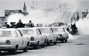  ?? ASSOCIATED PRESS FILE ?? Bloody Sunday: March 7, 1965. Tear gas filled the air as state troopers, ordered by Alabama Gov. George Wallace, broke up a march in Selma. Dramatical­ly similar scenes have been playing out in the U.S. lately, again raising the question about police violence and racism: Why, still?