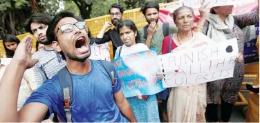  ?? Reuters ?? ↑ Protesters shout slogans during a rally in Delhi against the deaths of children who have died from encephalit­is in Bihar.