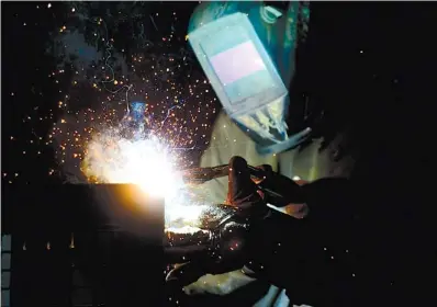  ?? THE CANADIAN PRESS VIA AP ?? A welder fabricates a steel structure at an iron works facility in Ottawa, Ontario, Monday.