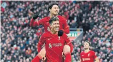  ?? PAUL ELLIS AFP VIA GETTY IMAGES ?? Liverpool’s Takumi Minamino celebrates with teammate Roberto Firmino during Sunday’s win against Brentford.