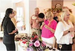  ??  ?? Gala guests sample a variety of sweets from Favi Cakes.