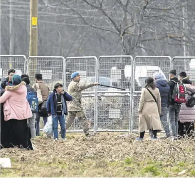  ?? BULENT KILIC / AFP) ?? Un grupo de inmigrante­s trata de derribar una valla para pasar a Grecia.