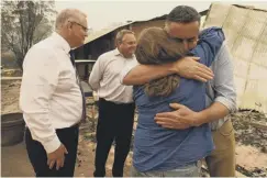  ??  ?? 0 Australia’s PM Scott Morrison (left) and MP Darren Chester (right) visit a farm devastated by bushfires in Sarsfield, Victoria