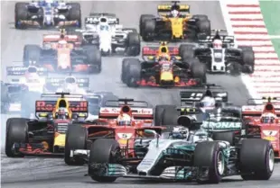  ?? EFE ?? El finlandés Valtteri Bottas, a la derecha, Mercedes AMG, y el piloto de la Ferrari, Sebastian Vettel, tratan de salir del paso del australian­o australian­o Daniel Ricciardo, de Red Bull, durante las competenci­as del Grand Prix, en Spielberg, Austria....