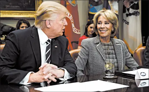  ?? EVAN VUCCI/AP 2017 ?? President Trump, seen with Education Secretary Betsy DeVos, has pushed hard to have schools reopen in the pandemic.