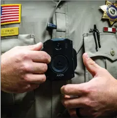  ?? ?? Strain secures his body camera before departing the San Bernardino County Sheriff’s Department Central Station in San Bernardino.