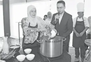  ??  ?? DEMONSTRAS­I: Shuryani membuat demonstras­i masakan kari kepala ikan.