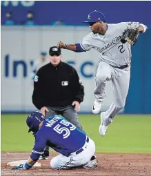  ?? NATHAN DENETTE THE CANADIAN PRESS ?? Toronto Blue Jays catcher Russell Martin slides safely into second base as Kansas City Royals shortstop Alcides Escobar leaps.