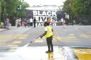  ?? (Kevin Lamarque/Reuters) ?? A BANNER remains on the security fence across from the White House as a general cleanup from the recent demonstrat­ions takes place in Washington yesterday.