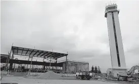  ?? AP Photo/Ted S. Warren ?? ■ Constructi­on of a privately run commercial U.S. airport terminal takes place April 11 near the control tower at Paine Field in Everett, Wash.