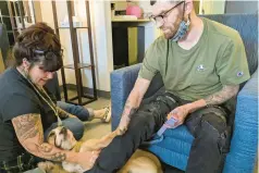  ?? ?? Donna Norton meets with Ian Dereus and his dog, Lola, at the hotel in Centennial, Colorado, where Norton helps people recovering from mental health and substance use disorders. Dereus is now considered a graduate and is living in his own apartment.