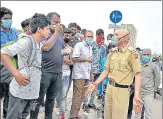  ?? BURHAAN KINU/HT ?? Police interact with migrant workers in Ghazipur. n