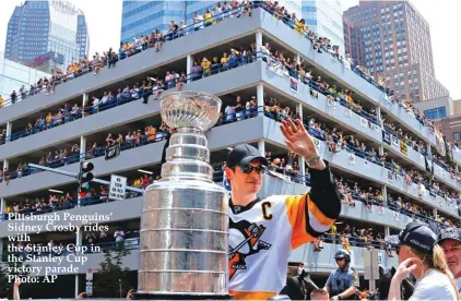  ??  ?? Pittsburgh Penguins’ Sidney Crosby rides with the Stanley Cup in the Stanley Cup victory parade Photo: AP