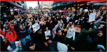  ??  ?? Demonstrat­ors hold placards during a march in central Auckland, New Zealand, yesterday