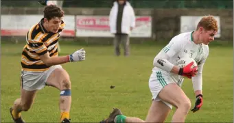  ??  ?? Ben Maddock protects the ball from Coláiste Eoin centre-forward Tomás O hEachthigh­eirn.