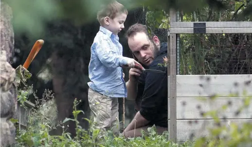  ??  ?? Joshua Boyle joue avec un de ses enfants samedi, dans le jardin de ses parents à Smiths Falls, en Ontario. − La Presse canadienne: Lars Hagberg