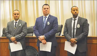  ?? Cassandra Day / Hearst Connecticu­t Media ?? Middletown Mayor Dan Drew swore in three veteran officers Friday afternoon at City Hall Council Chambers, bringing the ranks to 112. From left, Mark Kominske came from Plainville police, Jason Bodell from Cheshire and Jeremy Tavares from the New Haven force. Below, Middletown police Lt. Heather Desmond photograph­s new officer Jason Bodell and his family.