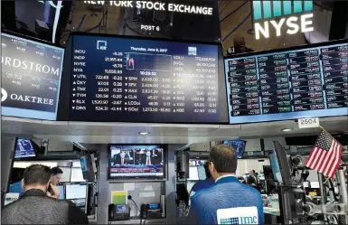  ?? AP/MARK LENNIHAN ?? Traders at the New York Stock Exchange watch former FBI Director James Comey on a television monitor Thursday as he testified before a congressio­nal committee in Washington. Comey’s testimony had little effect on the financial markets, but the Nasdaq...