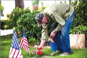  ?? NEWS-SENTINEL FILE PHOTOGRAPH ?? Jon Wiest of Sacramento sorts flowers on his parents' grave after the Memorial Day service held at Cherokee Memorial Park and Funeral Home on Monday, May 27, 2019.