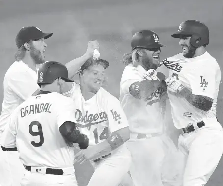  ?? HARRY HOW/GETTY IMAGES ?? The Los Angeles Dodgers, seen celebratin­g a victory over the division rival Arizona Diamondbac­ks on July 6 in Los Angeles, have won 29 of 33 games to compile the best record in Major League Baseball at 64-29. They next play in Chicago against the White...