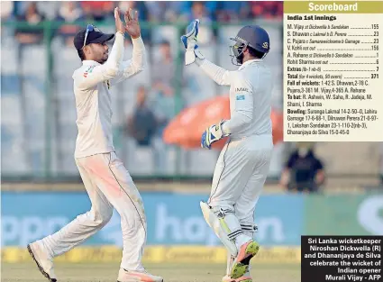  ??  ?? Sri Lanka wicketkeep­er Niroshan Dickwella (R) and Dhananjaya de Silva celebrate the wicket of Indian opener Murali Vijay - AFP