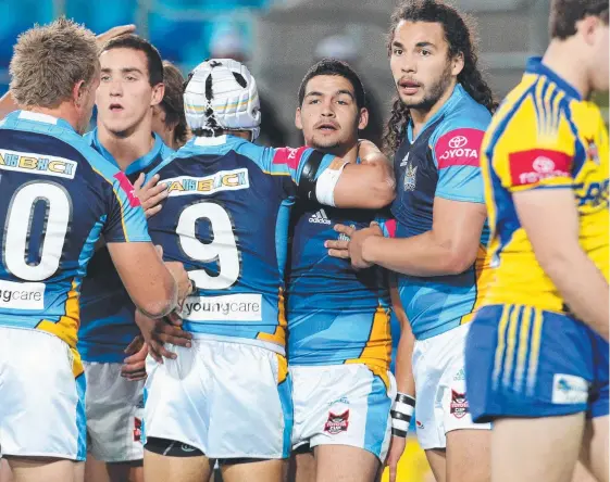  ?? Picture: ADAM HEAD ?? Cody Walker (centre) is congratula­ted by teammates including Ryan James after scoring for the Titans under-20s in 2010.