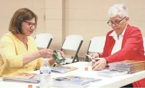  ?? PHOTOS BY BUCYRUS GERE GOBLE/TELEGRAPH-FORUM ?? Pam Holtshouse, left, and Major Debbra Grace of the Bucyrus Salvation Army prepare coloring books for shipment to Ukrainian refugees.