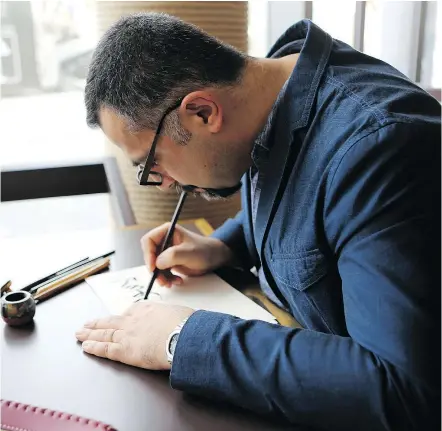  ?? — PHOTOS: THE ASSOCIATED PRESS FILES ?? Iraqi calligraph­er and artist Wissam Shawkat, who has been featured in Vogue Arabia and created the Arabic artwork for the magazine, works at a café at Dubai Design District in Dubai, United Arab Emirates.