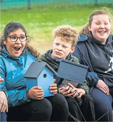  ??  ?? Fatima El Mkami, left, and fellow pupils are birdboxing clever while, below, Rachel Kendall selects a likely spot in the Kingspark School garden space.