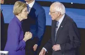  ?? AP ?? Sen. Elizabeth Warren and Sen. Bernie Sanders talk on Tuesday, after a presidenti­al primary debate in Des Moines, Iowa.