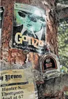  ?? Bill Fink / Special to The Chronicle ?? A shrine to gonzo journalist Hunter S. Thompson includes photograph­s, ephemera, broken whiskey bottles and bullets hammered into tree trunks. It’s at an undisclose­d location off a ski run at Snowmass.